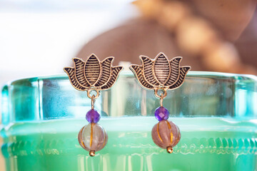 Lotus earrings with mineral stone beads hanging on decorative background