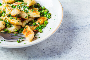 Gnocchi with peas, cheese and herbs. Italian cuisine concept.