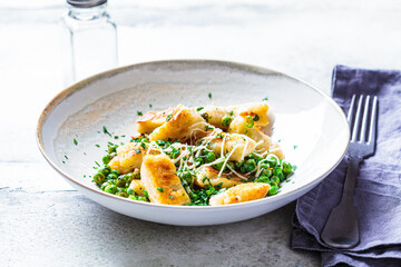 Gnocchi with peas, cheese and herbs. Italian cuisine concept.