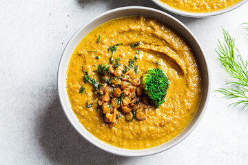 Lentil cream soup with broccoli and dill in gray bowl, top view. Healthy vegan food concept.
