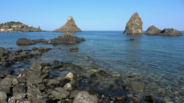 View of the Faraglioni of Acitrezza. Rocks of the Cyclops, typical lava stacks. Sicily, Italy. Footage 4k