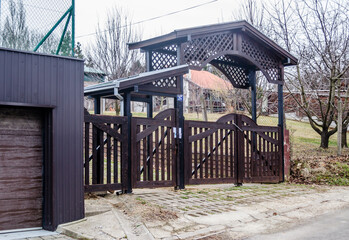Fototapeta na wymiar Closed, slatted, black wooden gate of private property. 