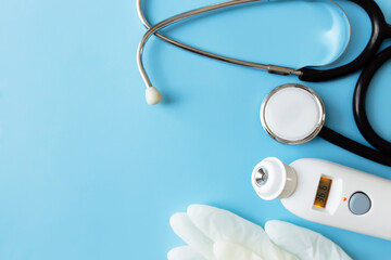 Medicine treatment concept. Electronic thermometer, stethoscope, white gloves