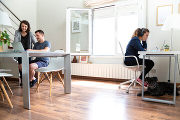 young people working on a project at home with their computers in a bright room. Work at home concept.