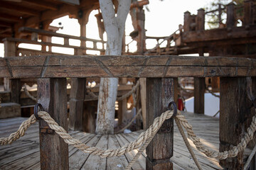 Wooden handrails with intertwined rope close up.