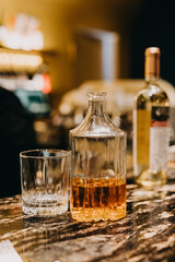 Bottle of whiskey and a glass on bar counter.
