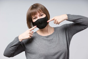 responsable woman pointing to her black face mask