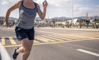 Young woman jogging on hot morning in tropical highlands.