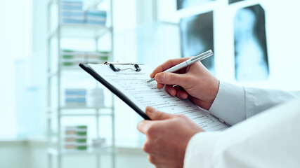 therapist is making an entry in the patient's registration card.