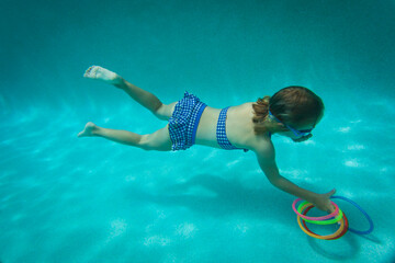 little girl swimming underwater, kid learning to dive