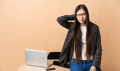 Chinese business woman in her workplace with neckache