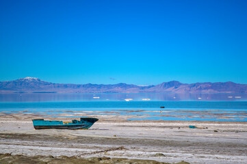 Fototapeta na wymiar Abandoned rusty boat on the salty shore of the Urmia Lake in Iran