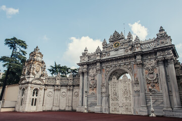 Fototapeta na wymiar Gate of historical Dolmabahce palace and clouds in sky at background, Istanbul, Turkey