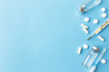 Medicine treatment, vaccination concept. Thermometer, vaccine, syringe, pills