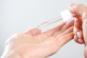 美容液を手に垂らす中年の日本人女性