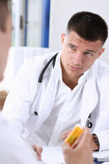 Male doctor hold in arms jar of pills