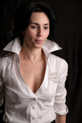 Fototapeta premium Portrait of beautiful mature brunette woman dressed in white shirt isolated on black background, copy space