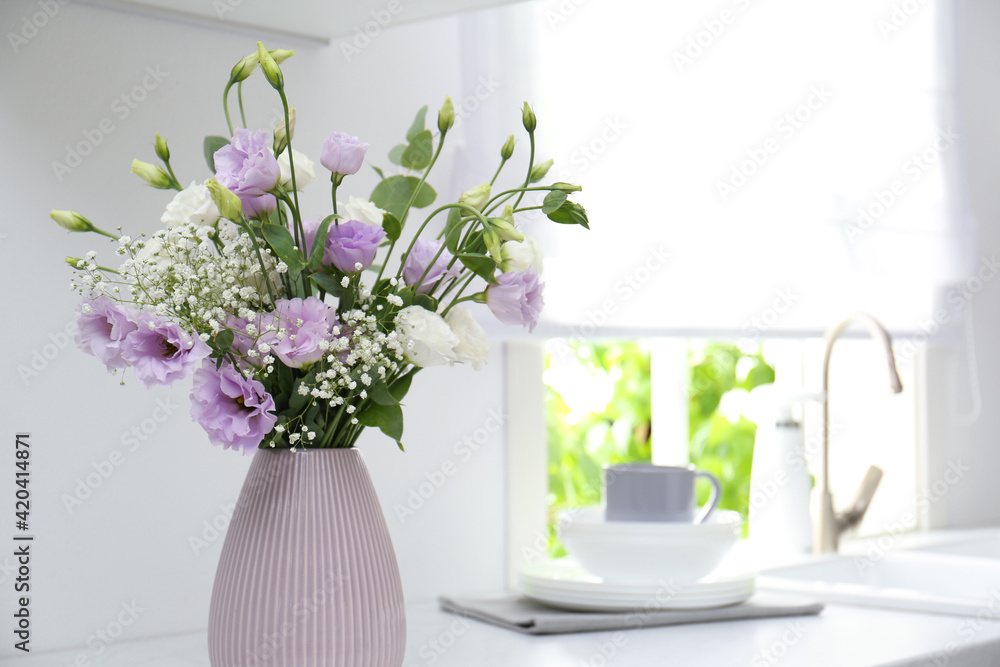 Sticker Beautiful bouquet with Eustoma flowers on countertop in kitchen, closeup. Space for text