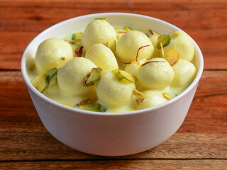 Angoori Rasmalai is an Indian dessert sweet with dry fruits and Saffron toppings, served in a bow. selective focus