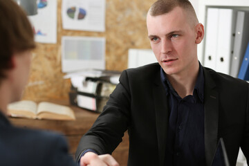 Smiling businessman shake hands as hello in office