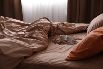 Bed with orange and brown linens in stylish room