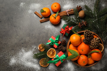 Obraz na płótnie Canvas Flat lay Christmas composition with fresh tangerines and gifts on grey background, flat lay. Space for text