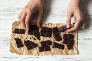 Broken chocolate bar on craft paper, top view