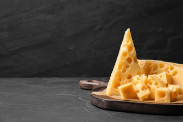 Tasty fresh cheese on dark grey table, closeup. Space for text