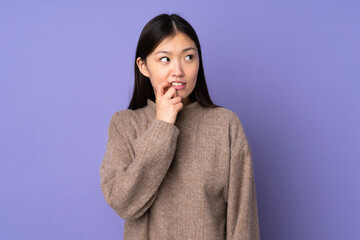 Young asian woman isolated on purple background nervous and scared