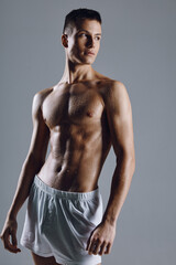 Fototapeta premium strong male athlete with flexed arm muscles on gray background cropped view