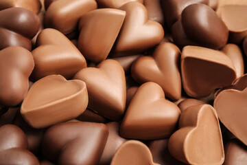 Tasty heart shaped chocolate candies as background, closeup. Valentine's day celebration