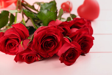 Obraz na płótnie Canvas Beautiful red roses on pink table, closeup. Valentine's Day celebration