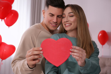 Lovely couple with gift in room. Valentine's day celebration