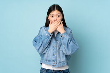 Young asian woman isolated on background covering mouth with hands