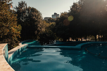 Artificial, cascade lake, and green trees in park