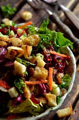 Fresh vegetable salad with croutons on a rustic plate