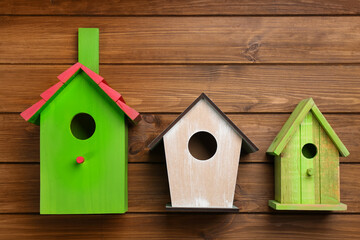 Obraz na płótnie Canvas Three different bird houses on wooden background