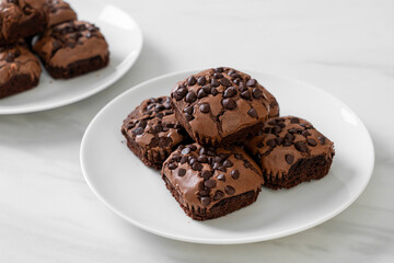 dark chocolate brownies topped by chocolate chips