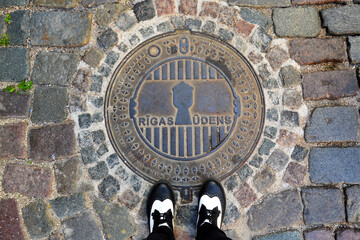 Hatchway in Riga and shoes on it (Rigas Udens - Riga water). Latvia, Baltic States