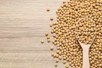 Soy and spoon on wooden table, flat lay. Space for text