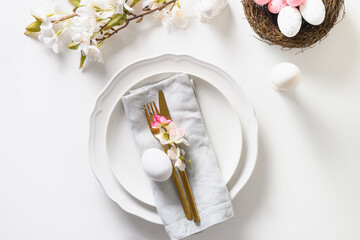 Easter table setting with blooming apple flowers on white table.