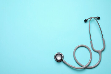 Stethoscope on light background, top view. Space for text
