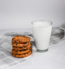 A glass of milk, chocolate oatmeal cookies and crumbs on a white background. The concept of proper nutrition and weight loss. copy space for text
