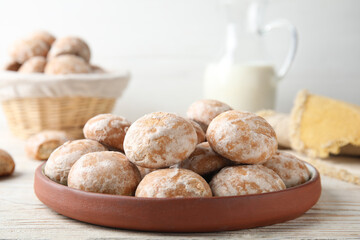 Plate with tasty homemade gingerbread cookies on white wooden table