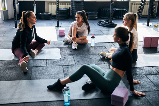 Puzzled young woman takling to young gymnasts