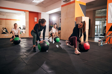 Strong young women working out with special fitness balls
