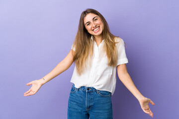 Fototapeta na wymiar Young woman over isolated purple background happy and smiling