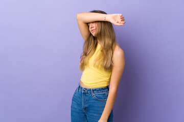 Young woman over isolated purple background covering eyes by hands