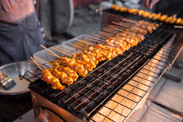chicken satay grilled on grills plate with smoke