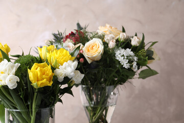 Beautiful bouquets with fresh flowers on grey background, closeup